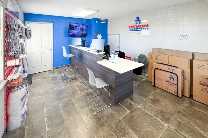Devon Self Storage office interior with customer service counter, security monitors, and packing supplies